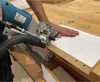 A person is using a dowel drilling machine on a piece of wood. Produktbild-Vorschau