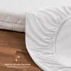 A white fitted sheet is draped over a mattress, with a wooden floor in the foreground. A graphic indicates it is ideal for cold weather. Produktbild-Vorschau