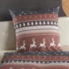 A close-up of a pillow with a winter-themed pattern, placed on a white surface. Produktbild-Vorschau