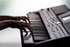 A close-up shot of hands playing a keyboard. Anteprima dell’immagine prodotto