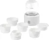 A white baby bottle warmer with several white bottle adapters arranged around it. Produktbild-Vorschau