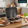 A sandwich maker is shown on a kitchen counter, with ingredients for burgers laid out. Produktbild-Vorschau