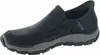 A black Skechers slip-on shoe with a gray sole is shown against a white background. Anteprima dell’immagine prodotto