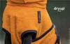 Close-up of a dog wearing an orange cape with navy trim. Produktbild-Vorschau