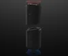 Two black cylindrical speakers are shown against a dark background. The top speaker is slightly separated from the bottom speaker, with a red circular object hovering above it. Náhled obrázku produktu