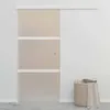 A sliding door with frosted glass panels and white trim, mounted on a wall. A laundry basket with towels is placed next to the door. Náhľad obrázku produktu