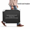 A person is carrying a folded black sun lounger. Produktbild-Vorschau