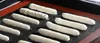 A baking mat with multiple rows of piped dough for eclairs or similar pastries. Podgląd zdjęcia produktu