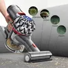 A hand holding a vacuum cleaner attachment, with circular insets showing microscopic images of allergens, dust mites, dust, and hair. Produktbild-Vorschau