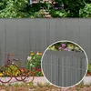 A garden scene with a fence, flowers, and a vintage tricycle. Produktbild-Vorschau
