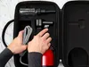 Hands are shown holding a portable steamer and its accessories inside an open carrying case. Produktbild-Vorschau