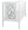 A white baby crib with a graphic of a teddy bear holding a heart on the headboard. Produktbild-Vorschau