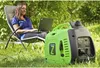 A woman is working on her laptop outdoors, with a portable generator nearby. Produktbild-Vorschau