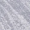 A close-up, textured view of a rug with an abstract, distressed pattern in shades of gray and white. Produktbild-Vorschau