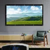 A projector screen displaying a landscape is mounted on a gray wall above a wooden cabinet. A chair with a blanket and pillow is to the right, and a projector is in the foreground. Voir les images du produit