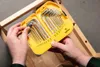 Hands holding a yellow case with a set of hex and Torx keys, positioned over a wooden structure. Anteprima dell’immagine prodotto