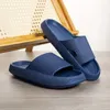 Paar marineblaue Slidesandalen mit dicken, geriffelten Sohlen und strukturierten Riemen, eine aufrecht stehend Anteprima dell’immagine prodotto