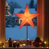 A decorative star lamp is displayed on a windowsill during winter, with snow and Christmas lights visible outside. Náhled obrázku produktu