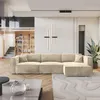 A modern living room with a large sectional sofa, bookshelf, and stairs. Produktbild-Vorschau