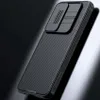 A black smartphone case with a sliding camera cover is shown against a dark, reflective background. Náhľad obrázku produktu