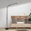 A floor lamp is positioned next to a desk with a chair in front of it. Produktbild-Vorschau