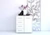 A white chest of drawers with decorative items on top, placed against a white wall. Náhľad obrázku produktu