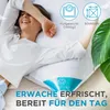 A woman is lying on a bed with a pillow, smiling. Produktbild-Vorschau