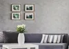 A living room scene with a sofa, coffee table, and framed pictures on the wall. Náhľad obrázku produktu