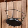 A black metal balcony holder for a flower pot hangs on a wooden fence. Podgląd zdjęcia produktu