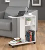 A white rolling side table with a laptop, a plant, and books, next to a gray armchair. Podgląd zdjęcia produktu