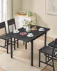 A dining table set with plates, cups, and a vase of flowers, set in a dining room. Produktbild-Vorschau