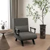 A dark gray armchair with a pillow is placed in a room with a plant and a side table. Produktbild-Vorschau