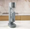 A gray soda maker sits on a countertop in a kitchen. Podgląd zdjęcia produktu