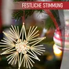 A straw star Christmas ornament hangs on a decorated Christmas tree with a red and white overlay banner at the top. Produktbild-Vorschau