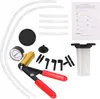 A collection of automotive tools, including a vacuum pump, hoses, adapters, and a gauge, laid out on a white background. Anteprima dell’immagine prodotto