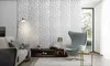 A modern living room with a textured white wall, a sofa, an armchair, and a coffee table. Produktbild-Vorschau