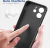 A hand is touching the back of a black phone case, highlighting its matte texture. In the background, there are fluffy white objects, possibly cotton balls, and text in German. Produktbild-Vorschau