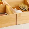 A close-up view of bamboo storage boxes containing a small brush and a pumice stone. Produktbild-Vorschau