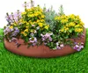 A planter filled with yellow and purple flowers, placed on green grass. Podgląd zdjęcia produktu
