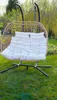 A hanging chair with cushions in a garden setting. Podgląd zdjęcia produktu