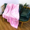 A pink blanket with a moon and star pattern is draped over a chair. Produktbild-Vorschau