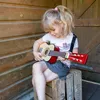 A young girl playing a toy guitar. Náhled obrázku produktu