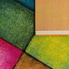 A close-up abstract view of a colorful, textured rug with geometric sections. Produktbild-Vorschau