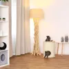 Two cats are playing around a cat scratching post and a floor lamp in a living room. Produktbild-Vorschau