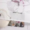 A close-up view of a sheer curtain with a floral pattern, showing a portion of a decorative element at the bottom. Produktbild-Vorschau