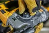A close-up shot of a person wearing yellow work gloves adjusting a setting on a yellow and gray power tool. Produktbild-Vorschau