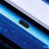 A close-up shot of a USB-C port on a blue electronic device. Produktbild-Vorschau