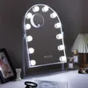 A vanity mirror with lights is displayed on a desk, with some decorative items and perfume bottles in the background. Produktbild-Vorschau