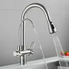 A stainless steel kitchen faucet with a pull-down sprayer and a separate filtered water spout is shown in a kitchen setting. Náhled obrázku produktu