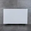 A white radiator panel is shown mounted on a gray tiled wall. Produktbild-Vorschau